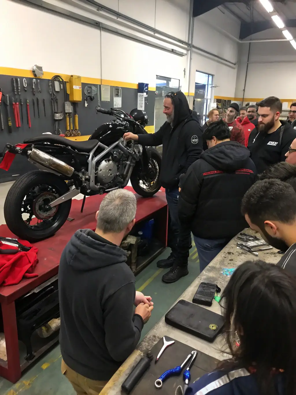 A photo of IronPulse Riders members participating in a motorcycle maintenance workshop, learning about basic repairs and upkeep.